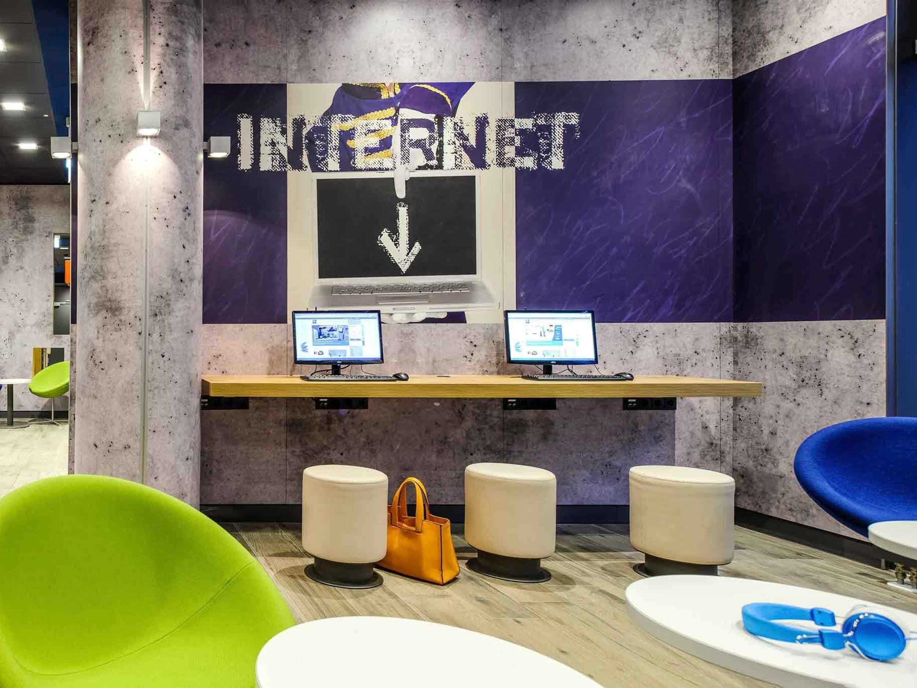 A workspace with two computers, a large 'INTERNET' sign, and modern seating.