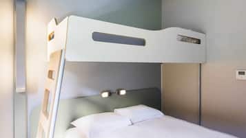 Una cama litera con cabecera, una mesita de noche y un termostato instalado en la pared.