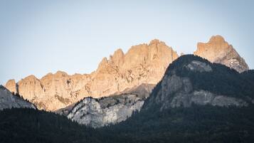 A mountain landscape with rugged cliffs and dense forest.
