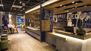 Ein modernes Restaurant mit Theke, Sitzbereich und dekorativer Wandkunst.
