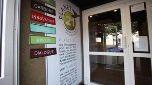 Ein Schild mit dem Text 'Planet 21' und Begriffen wie 'Natur', 'Kohlenstoff', 'Innovation', 'Lokal', 'Dialog' und 'Beschäftigung'.