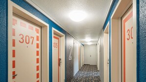 Ein Flur mit den Nummern 307, 305 und 2 auf den Türen, der zu Zimmern führt.