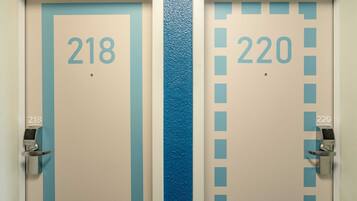 Dos puertas, una con la etiqueta 218 y la otra con la etiqueta 220, con una franja azul en el medio.
