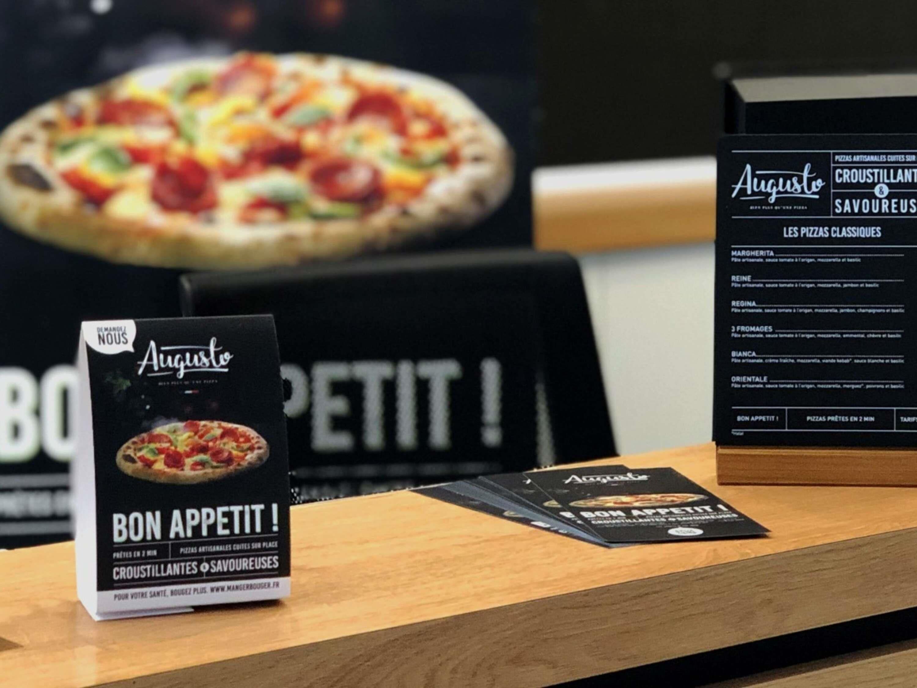 Un panel con el menú de pizzas y un anuncio para Augustino's.