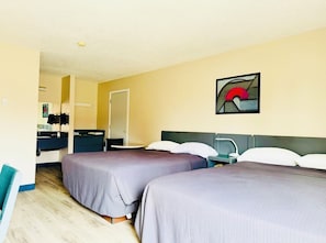 Hotellihuone, jossa on kaksi sänkyä, työpöytä, tuoli ja kylpyhuone.