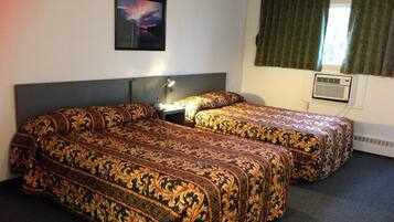 A hotel room with two beds, a nightstand, a lamp, a picture on the wall, and an air conditioning unit.