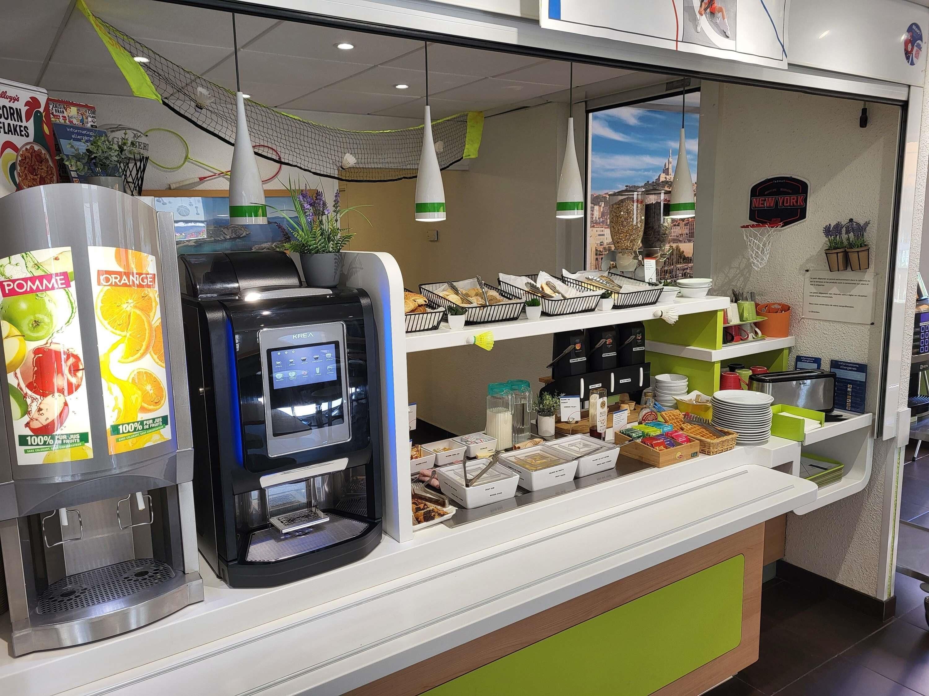 Um posto de bebidas com serviço próprio, tela digital, diversas opções de comida e vista para a cidade de Nova York pela janela.