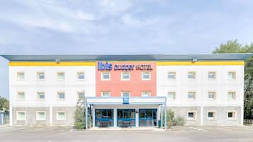 A hotel with a yellow and white facade, a blue entrance, and a sign reading 'ibis budget hotel'.