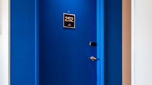Une porte bleue avec une plaque indiquant le numéro « 252 » et un petit logo.