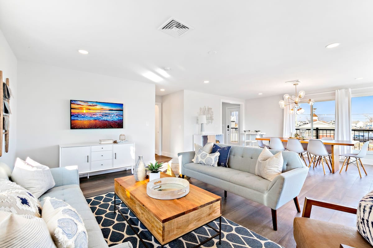 A modern living room with a sofa, coffee table, and dining area.