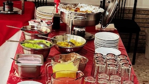 Una mesa de buffet con diferentes alimentos y utensilios.