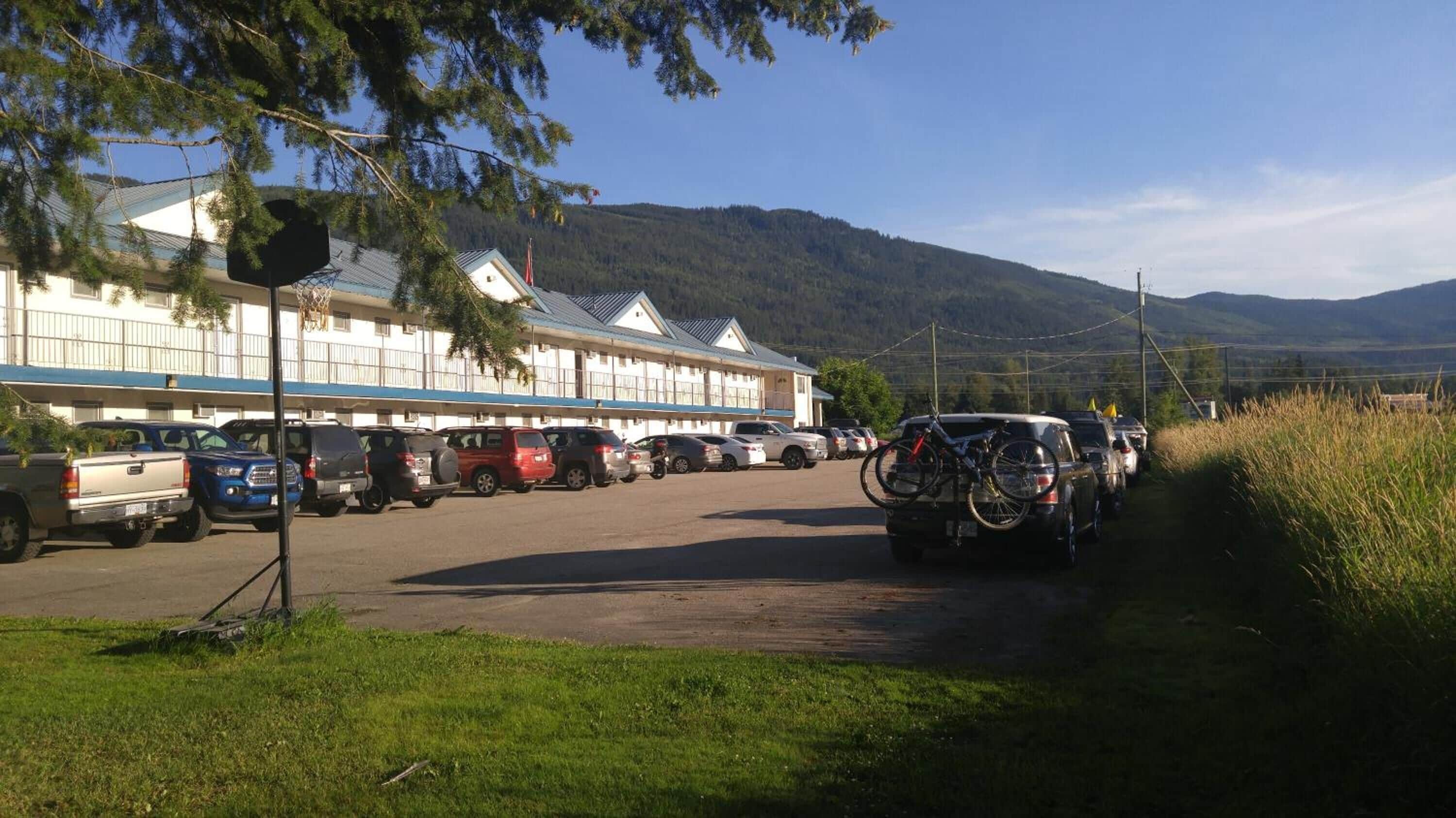 Een parkeerplaats met verschillende auto's en een fietsenrek.