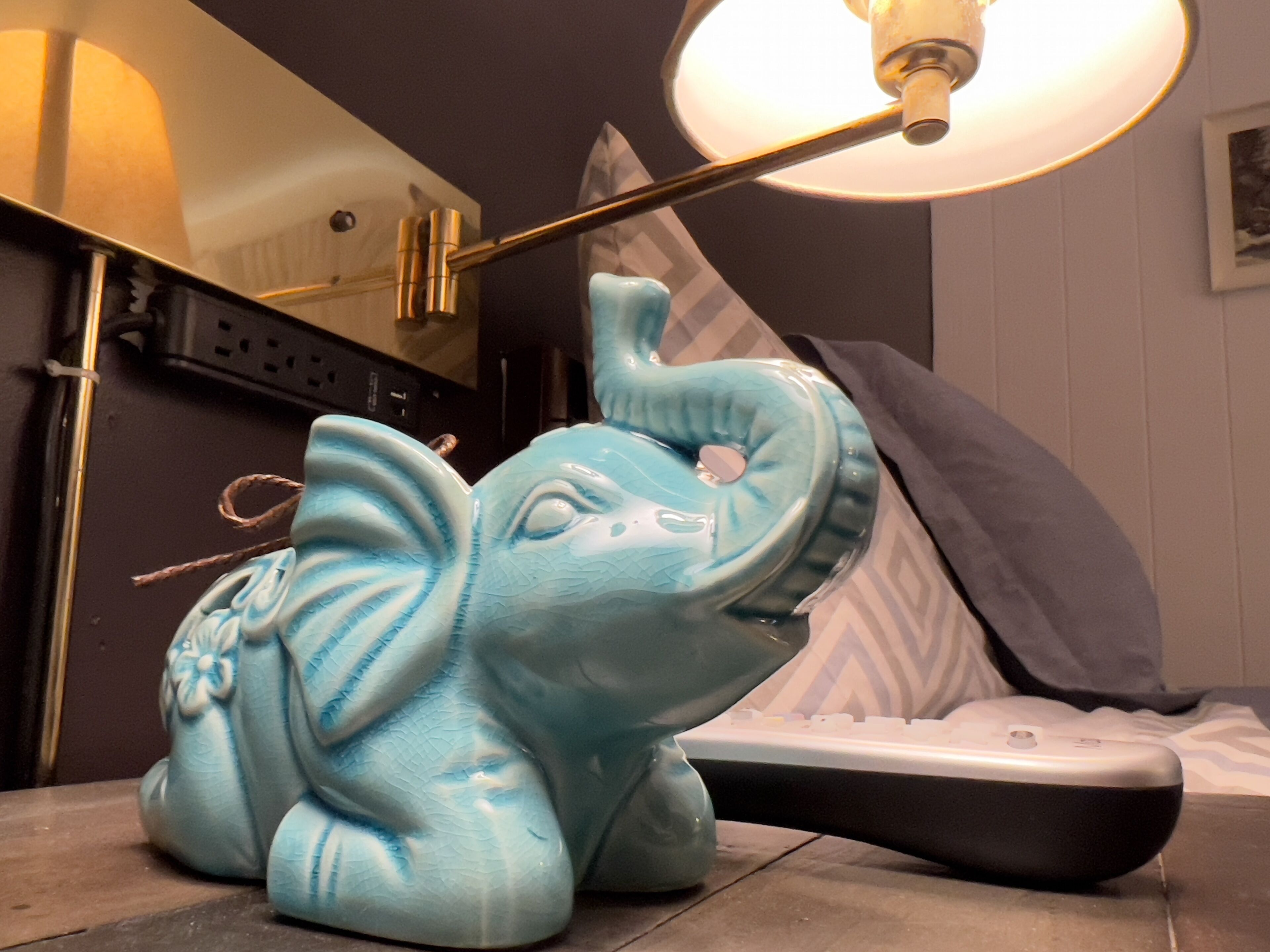 Eine blaue, elefantenförmige Lampe steht auf einem Tisch neben einer Fernbedienung.