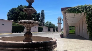 Une fontaine, un bâtiment avec une enseigne et un ciel dégagé.