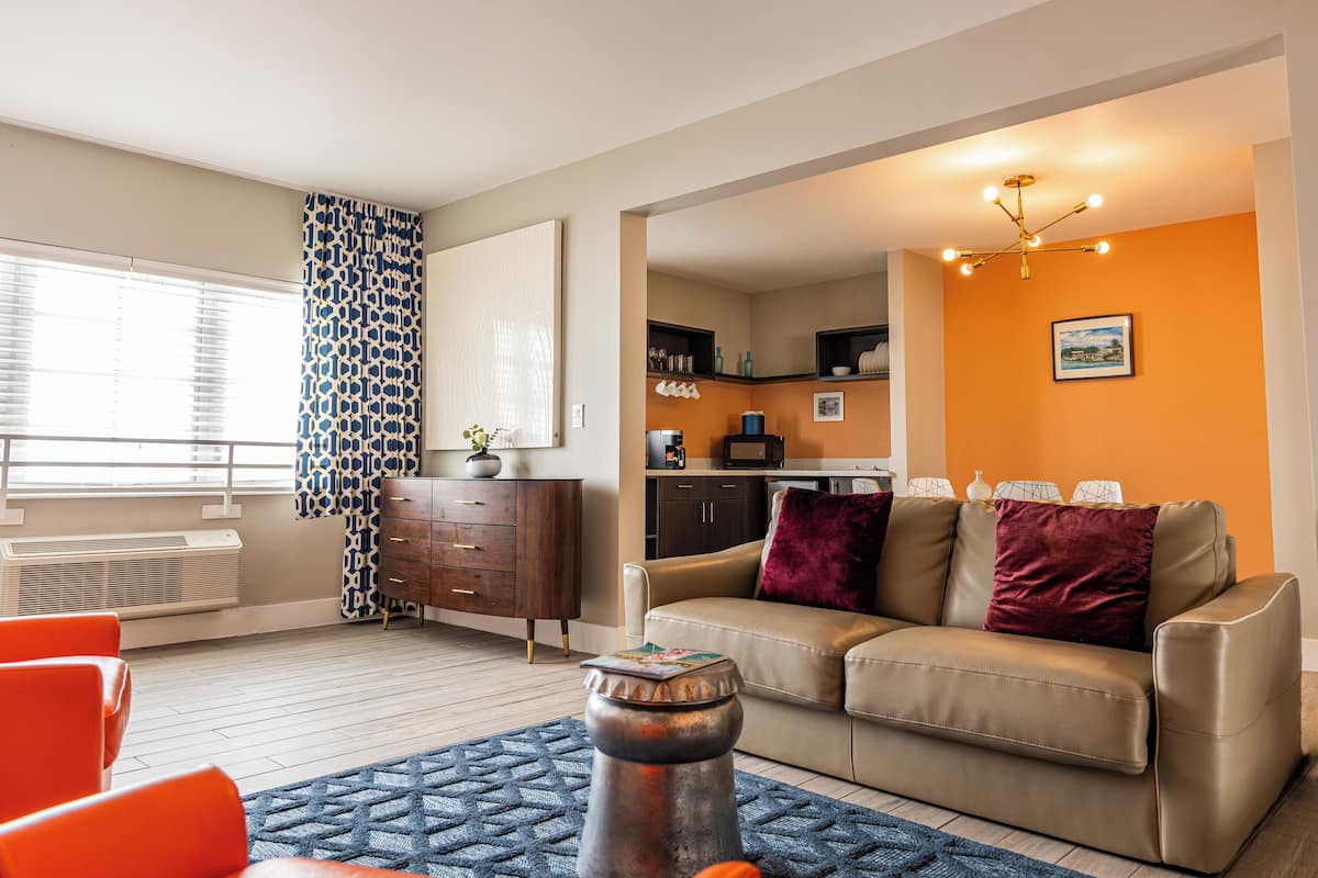 Un salon moderne avec un canapé, une table basse et un tapis à motifs.