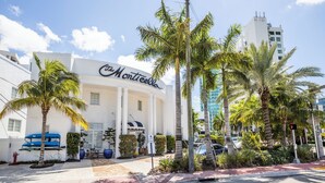 A hotel with a white facade and palm trees in front. - Oceanside Hotel and Suites (Miami Beach)