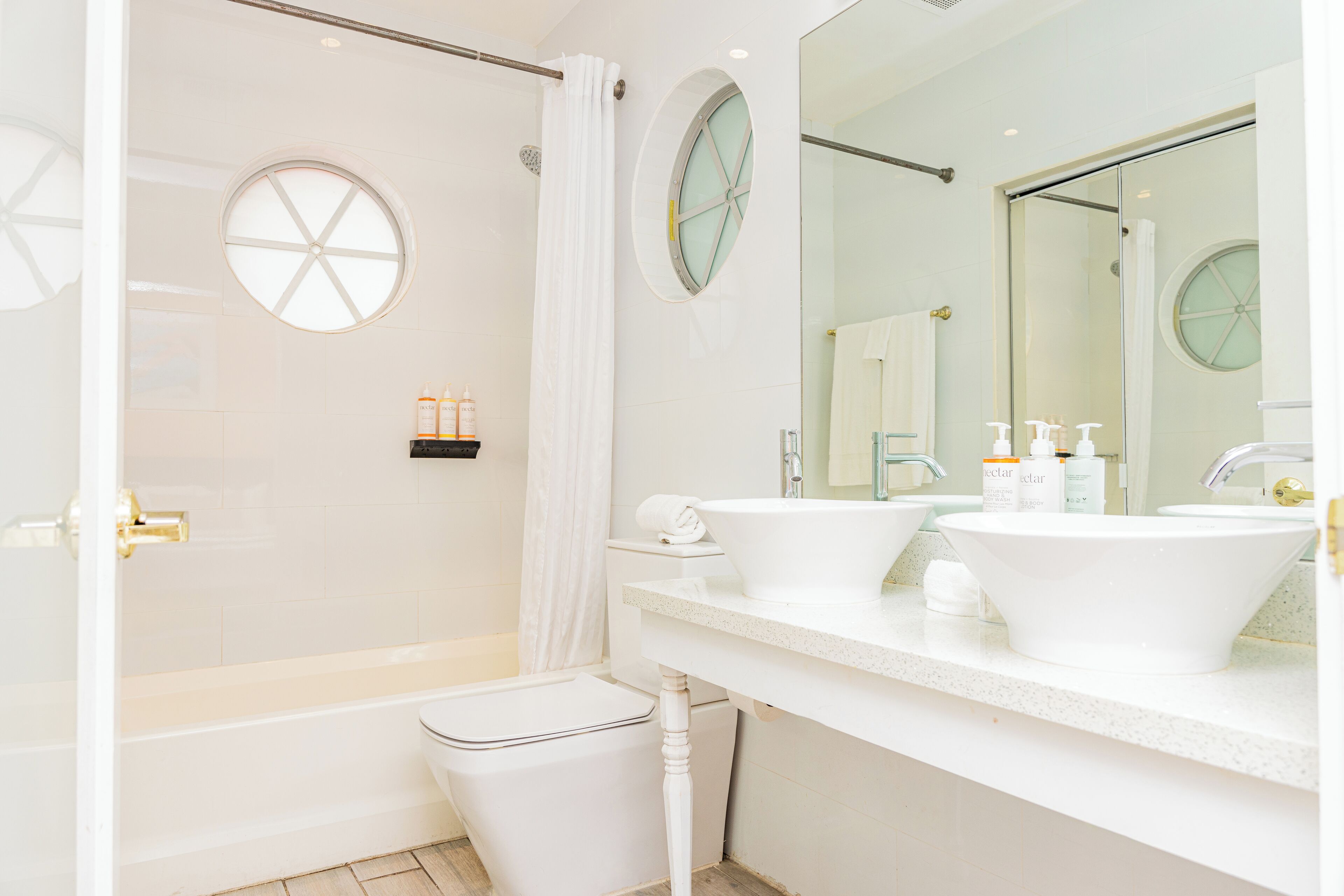 A modern bathroom with a glass-enclosed shower, two sinks, and a large mirror.