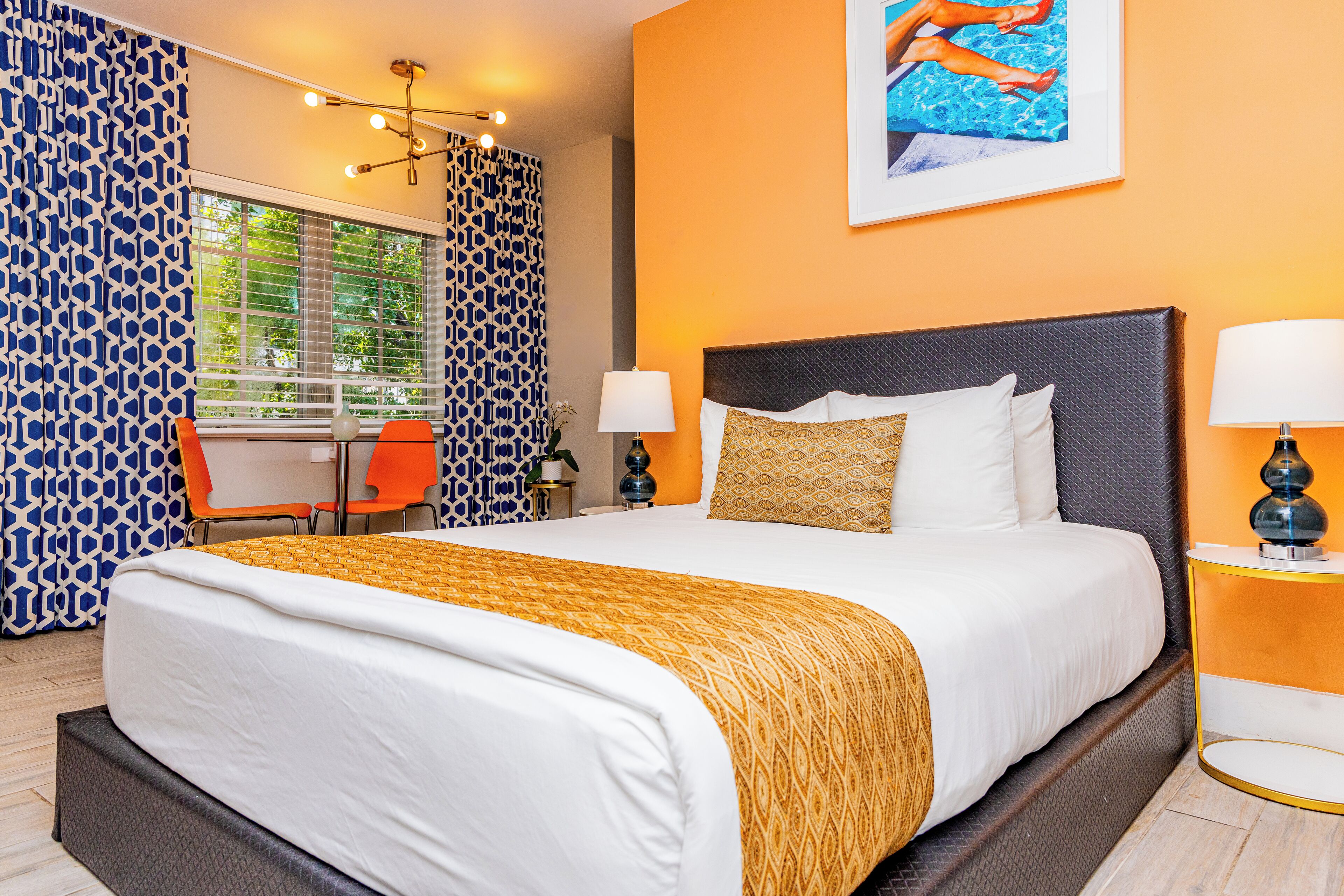 Une chambre d’hôtel avec un grand lit, deux tables de chevet, un bureau et une chaise.