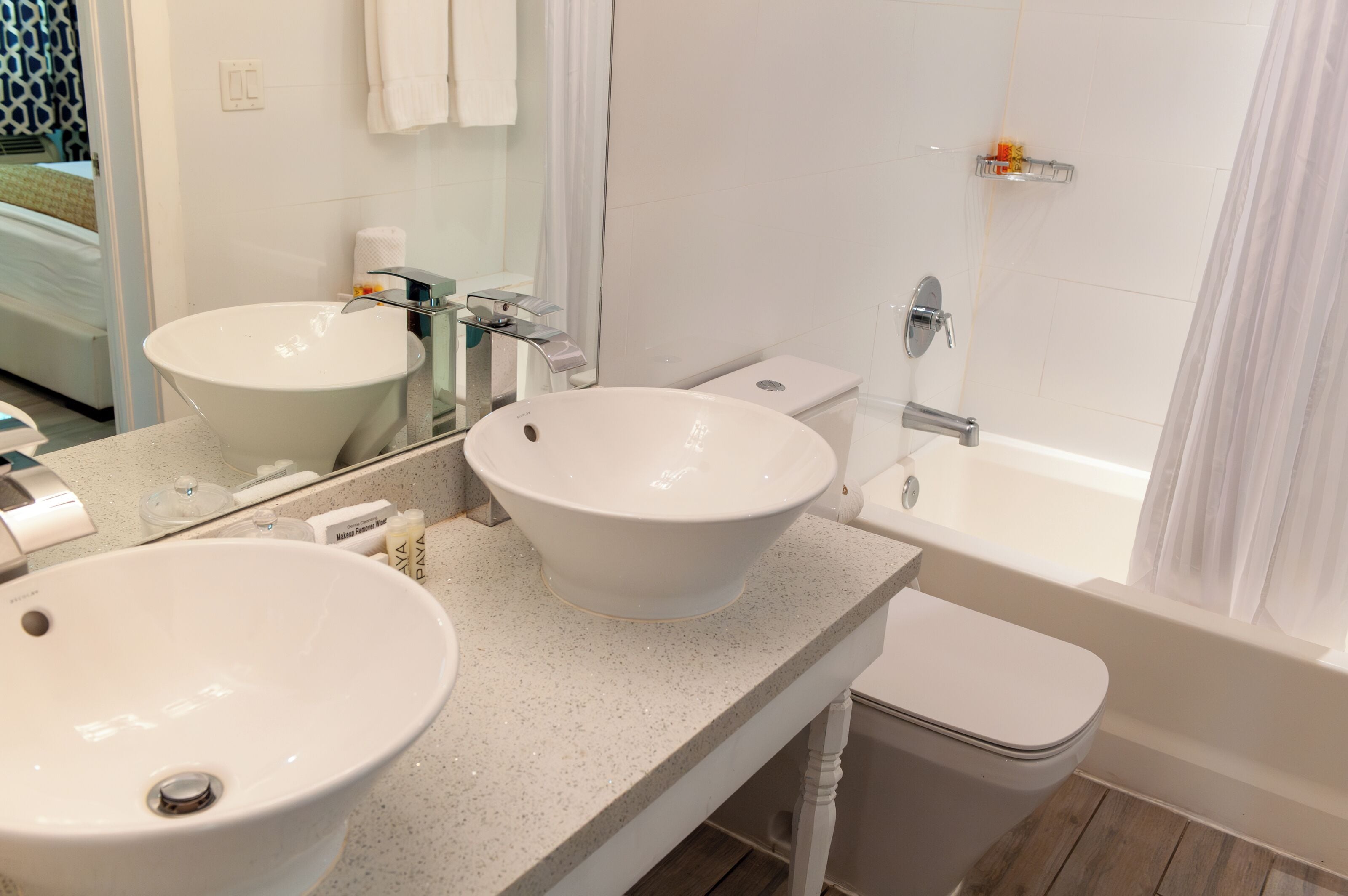 Ein Badezimmer mit zwei Waschbecken, einem Spiegel, einer Toilette und einer Badewanne.
