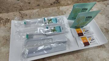 Una bandeja con varios artículos de aseo, como cepillos de dientes, pasta dental y champú.