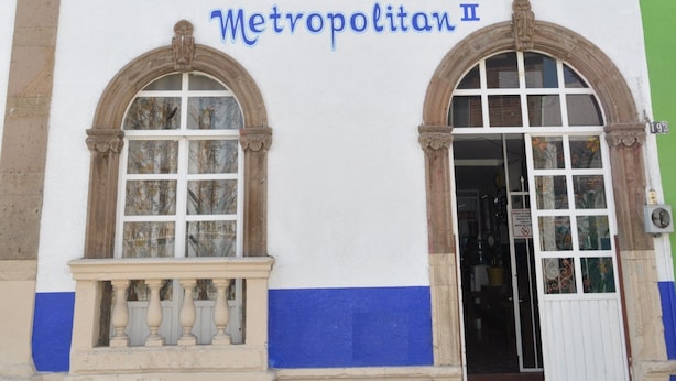 Fachada de hotel con el nombre "HOTELES Metropolitan II" en letras azules grandes.
