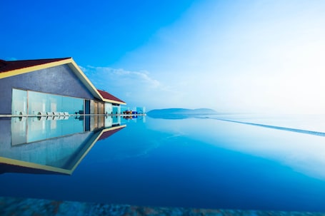 Una piscina al aire libre, sillones reclinables de piscina