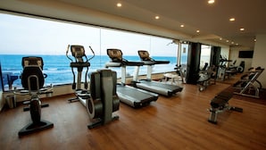 A gym with treadmills, stationary bikes, and weight machines, overlooking the ocean. - The Bheemli Resort - Managed by AccorHotels (Bhimunipatnam)
