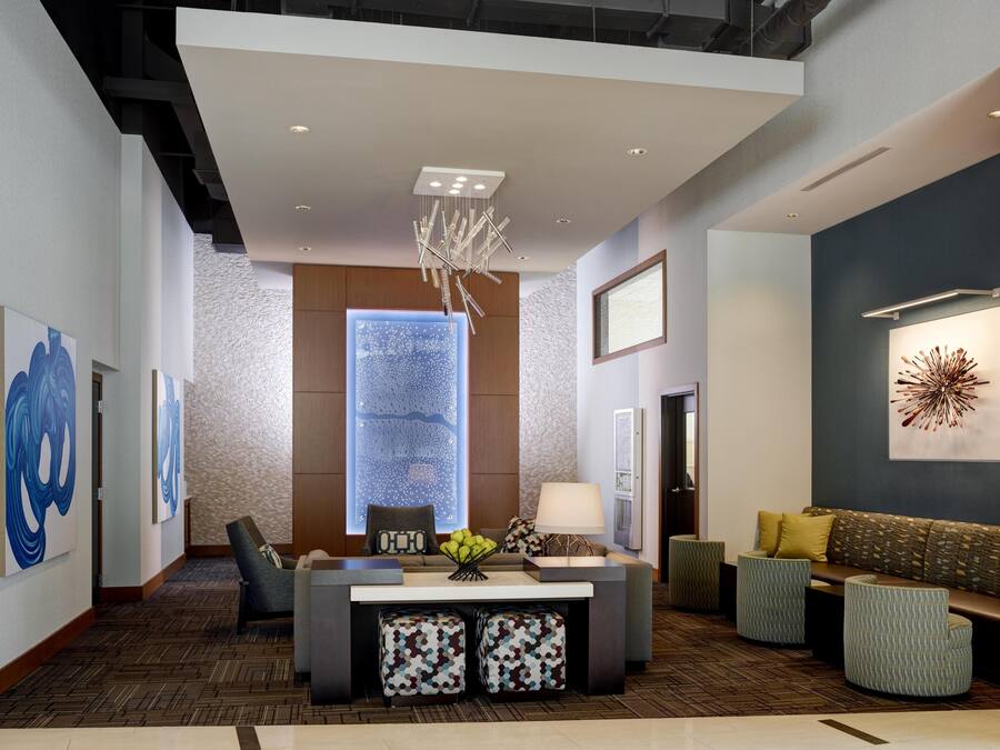 A modern lobby with a reception desk, seating area, and artwork.