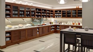 Une cuisine moderne avec des meubles en bois, un bar pour prendre le petit-déjeuner et des luminaires suspendus.