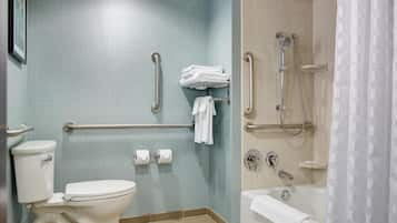 A bathroom with a toilet, a shower with a handheld showerhead, and a bathtub.