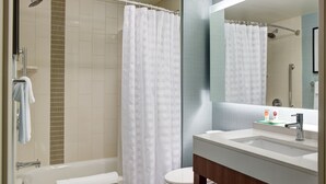 Une salle de bain moderne équipée d’une baignoire, de toilettes et d’un espace douche.