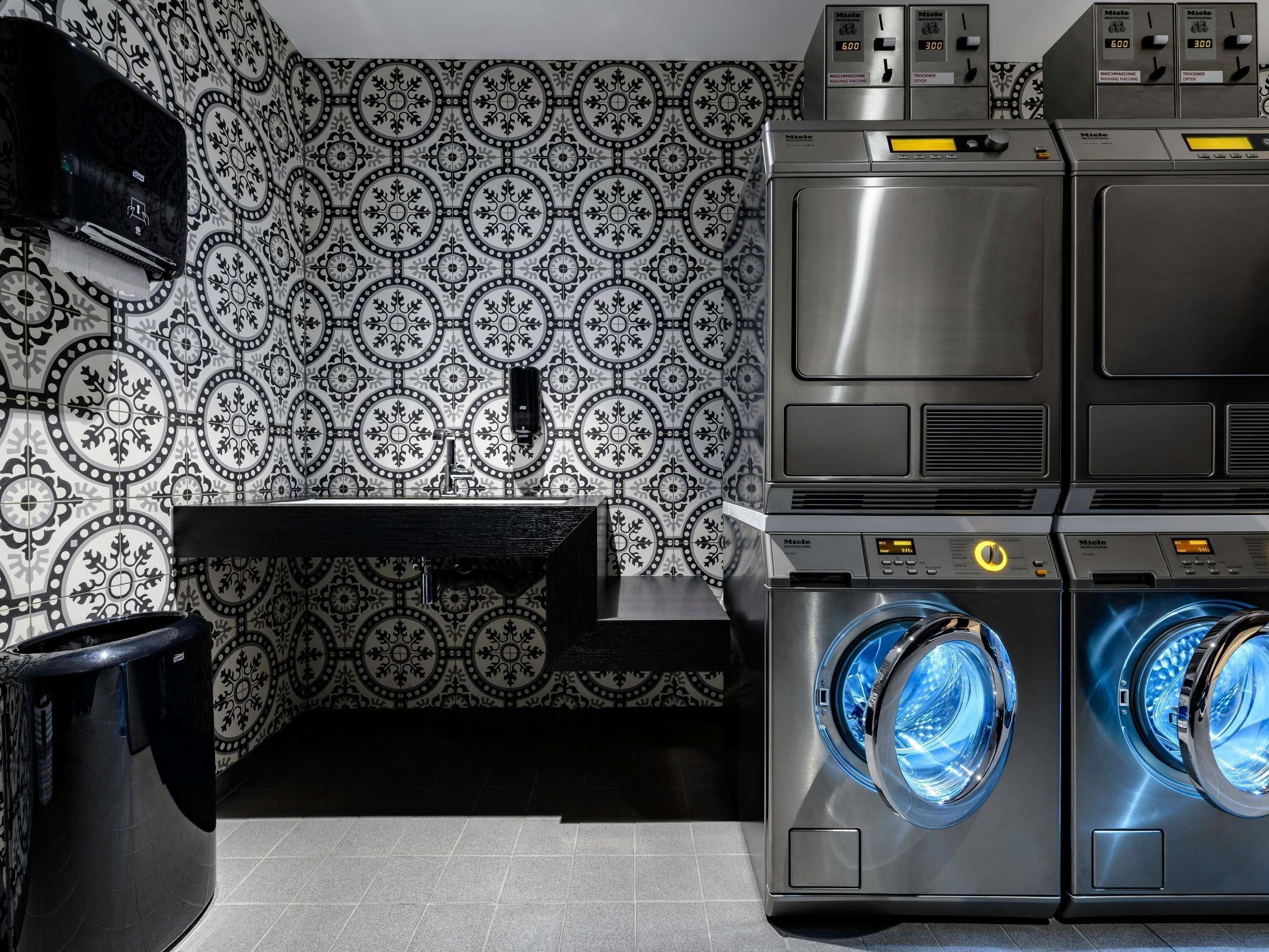 A laundry area with a washing machine, dryer, and a wall-mounted heater.