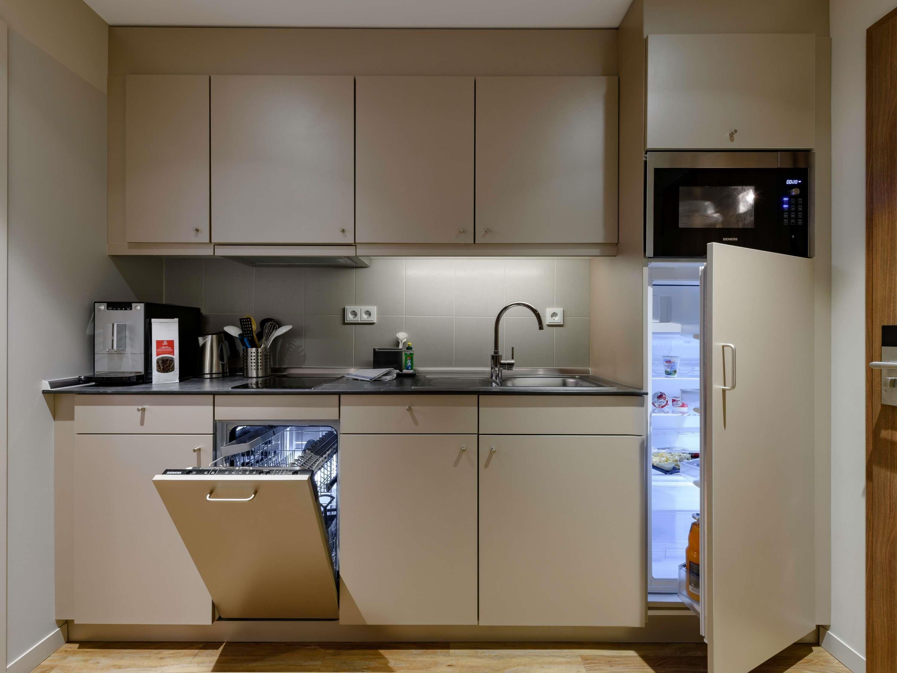 A modern kitchen with a dishwasher, a microwave, and a refrigerator.