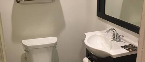 A bathroom with a toilet, sink, and a towel rack.