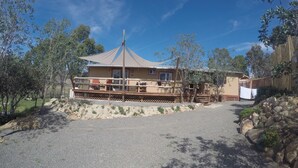 A two-story building with a covered patio and a fenced deck.