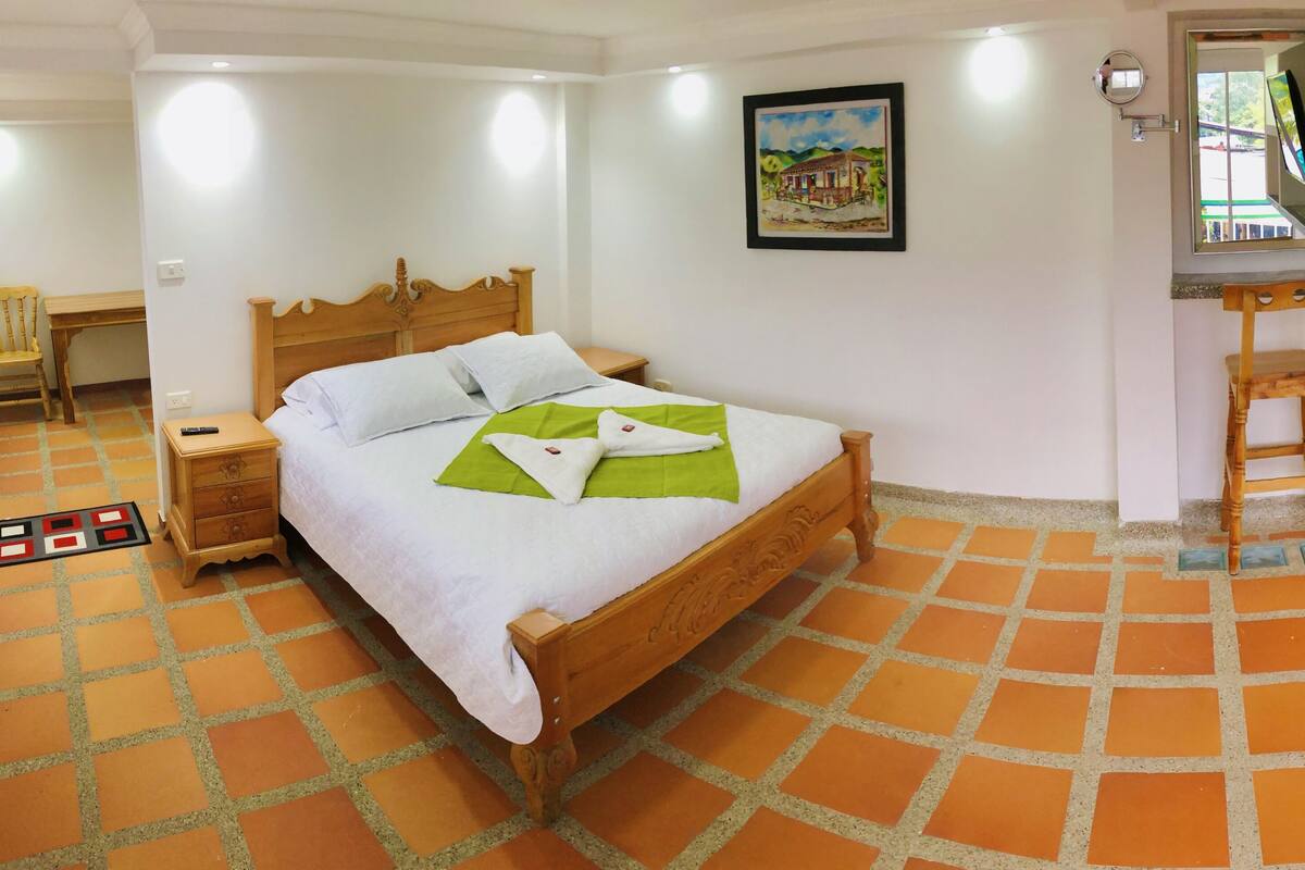Ein ordentlich eingerichtetes Schlafzimmer mit einem hölzernen Bett, einem Schreibtisch und einem Stuhl.
