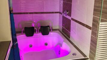 Ein modernes Badezimmer mit Eckbadewanne, Duschbereich und Duschabtrennung aus Glas.