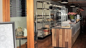 A bar area with wooden shelves, a bar counter, and hanging lights. - Stuart Range Outback Resort (Coober Pedy)