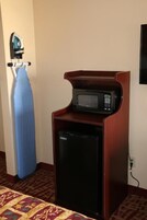 Uma cozinha compacta com micro-ondas e um refrigerador pequeno.