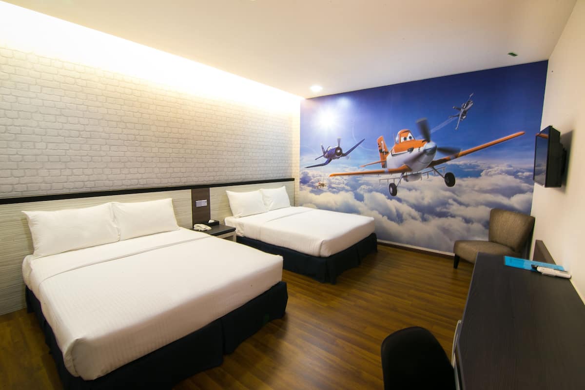 Une chambre d’hôtel avec deux lits, un bureau et une fresque représentant des avions.