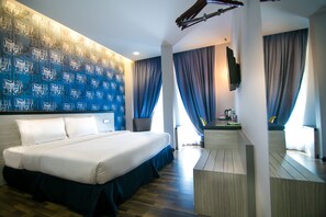 Habitación de hotel con una cama grande, un televisor de pantalla plana en la pared y suelo de madera.