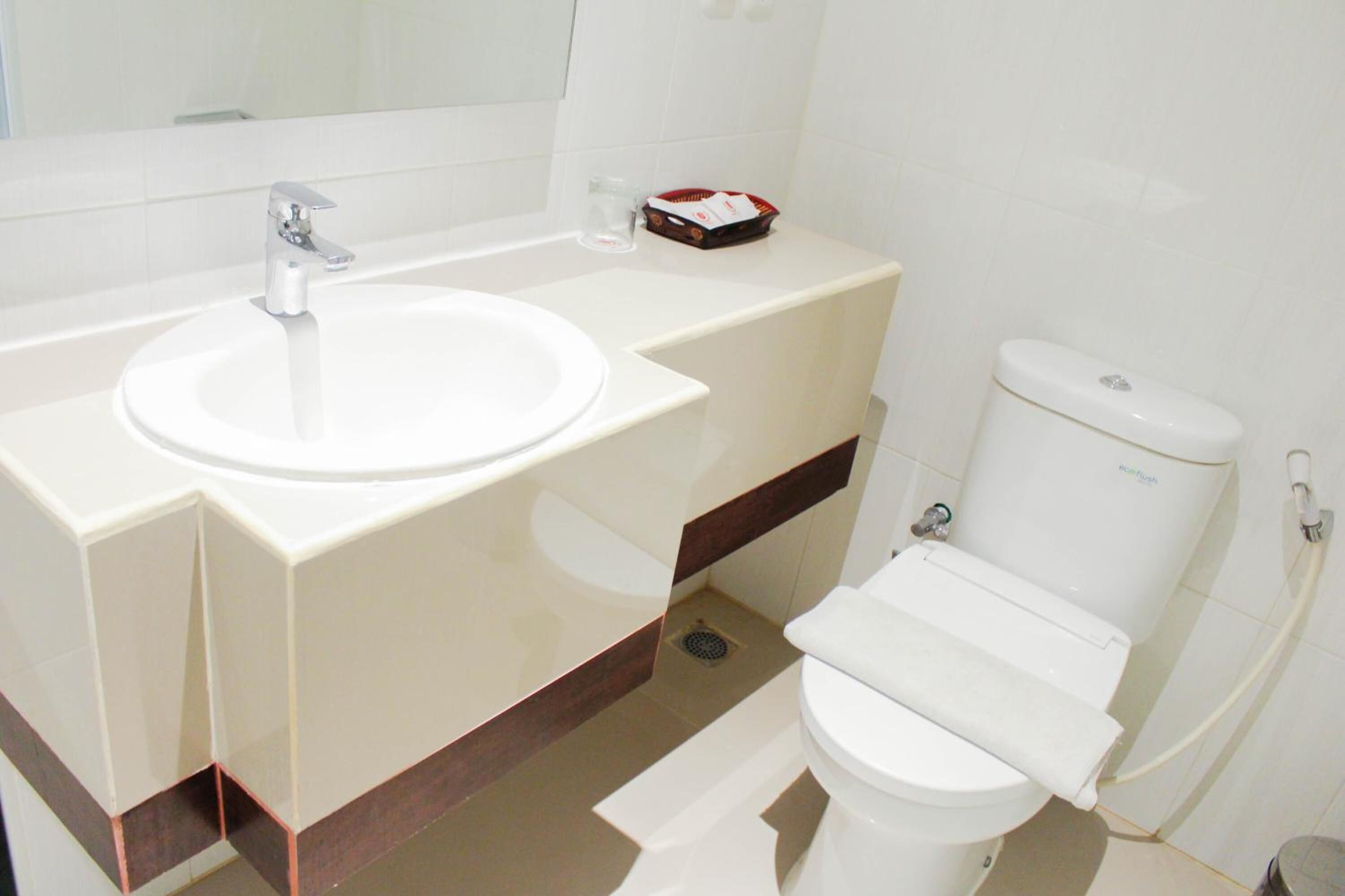 Ein Badezimmer mit Waschbecken, Spiegel und Toilette.