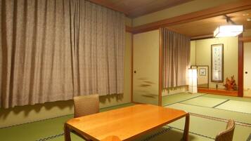 A traditional Japanese room with tatami flooring, a wooden table, a chair, and sliding doors.