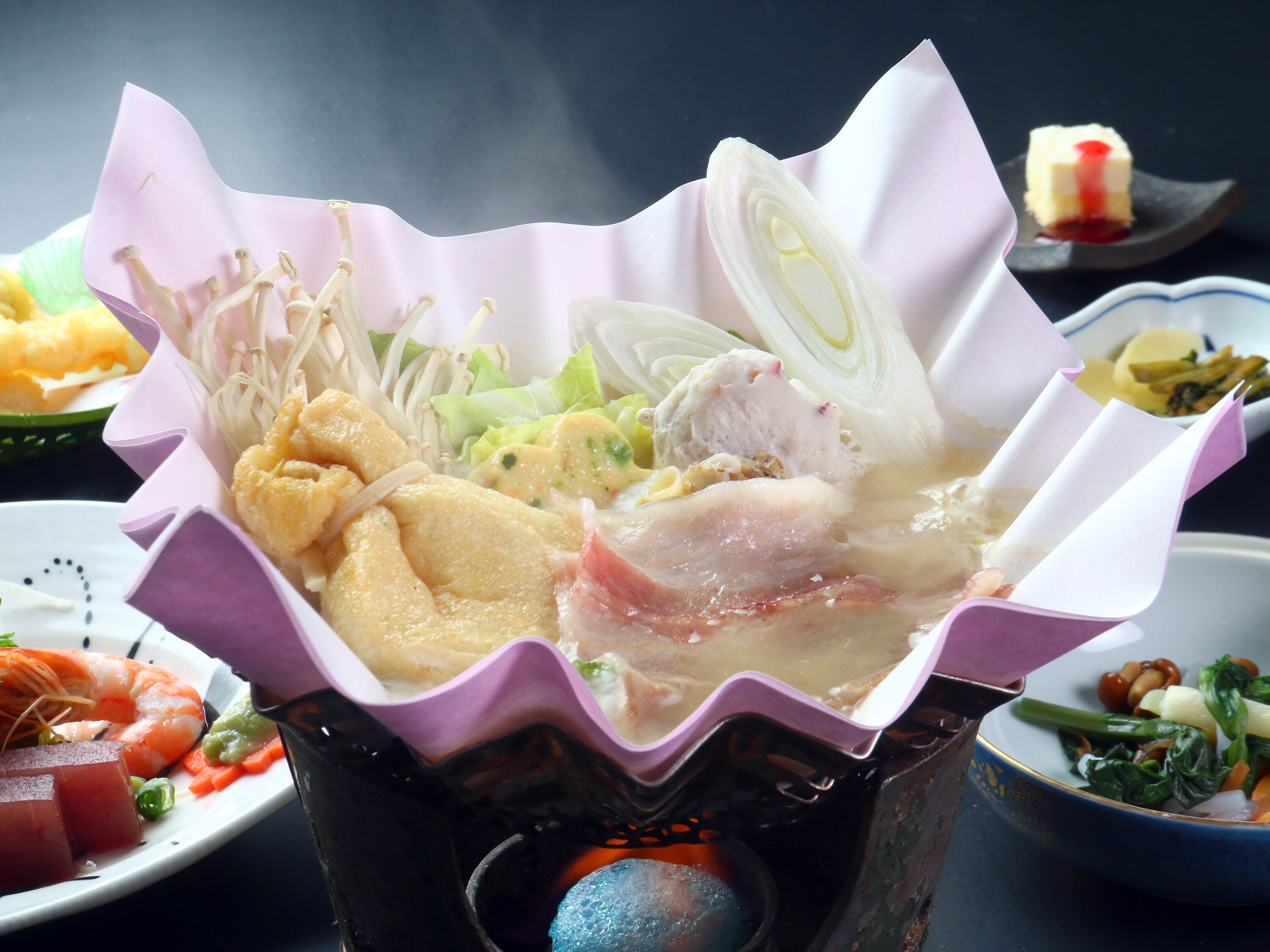 A bowl of soup with various ingredients, including vegetables and meat, served in a paper cup.