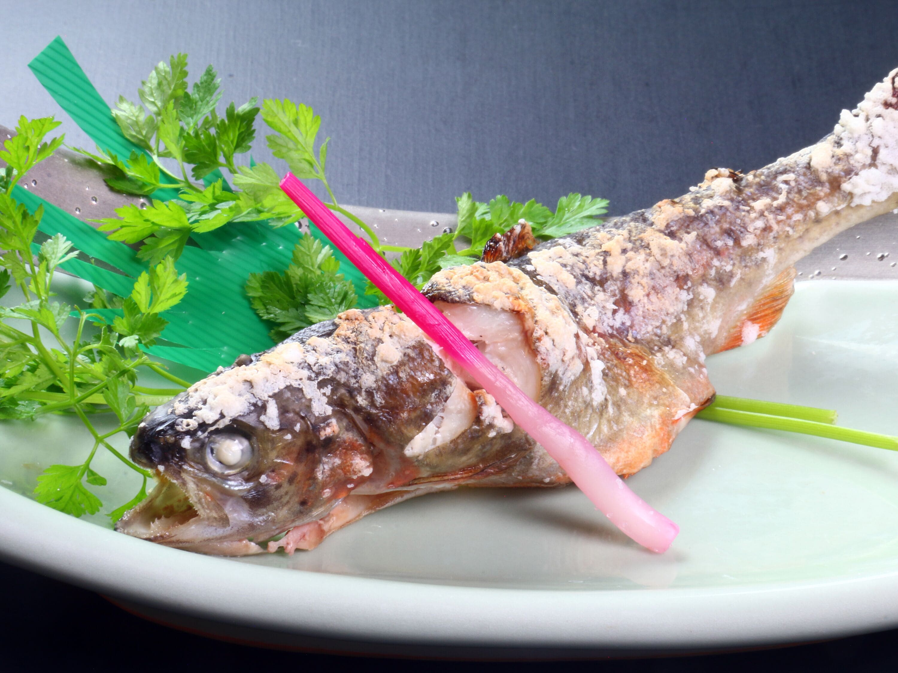 Un plato de pescado decorado con perejil.
