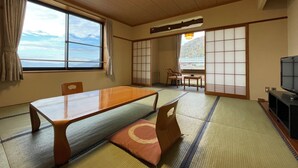 Una habitación japonesa tradicional con suelo de tatami, una mesa baja y puertas correderas.