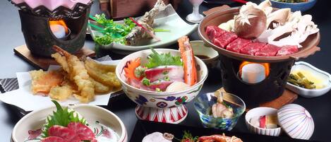 A variety of Japanese dishes including sushi, sashimi, and tempura, arranged on a table.