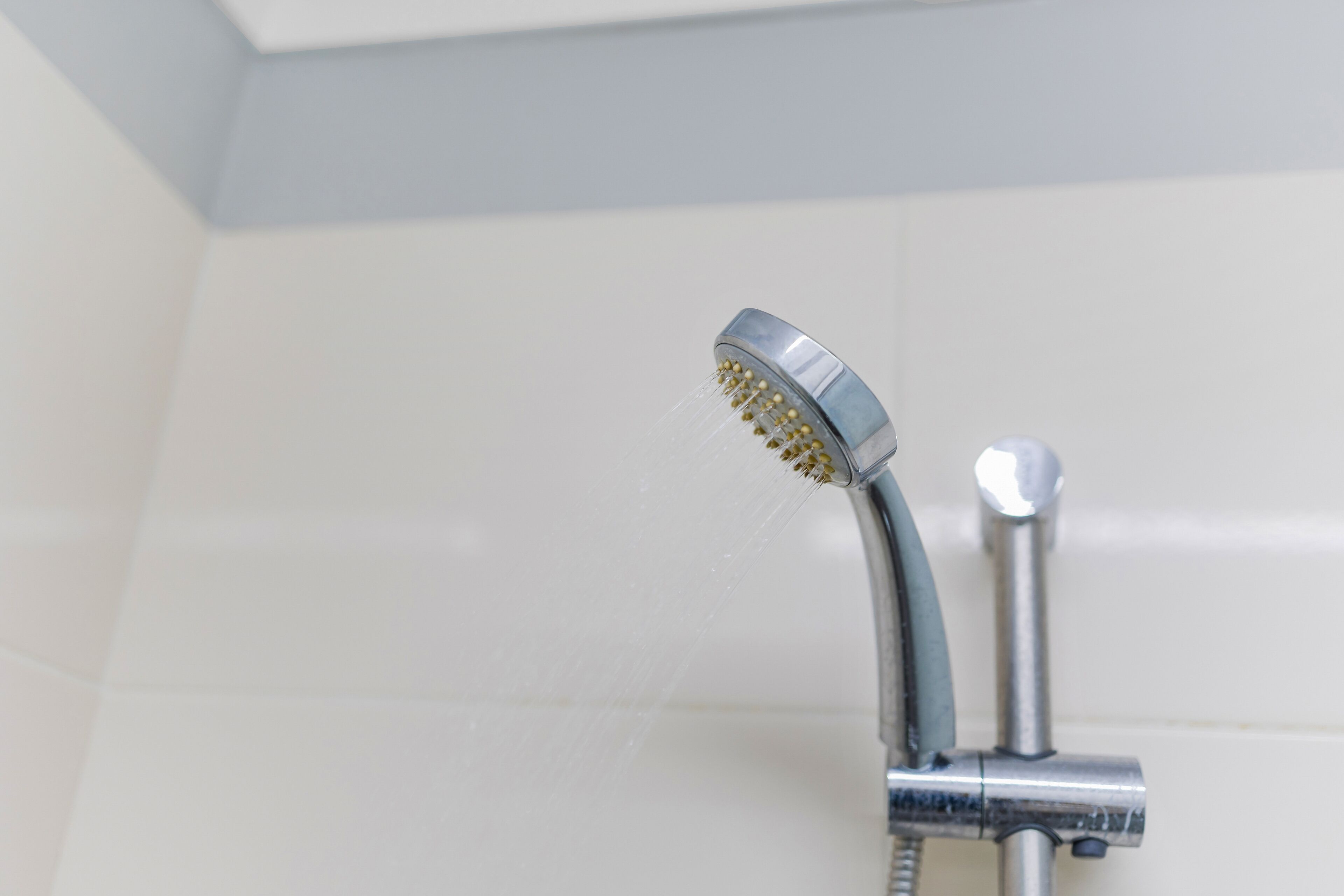 Un pommeau de douche d’où jaillit de l’eau.