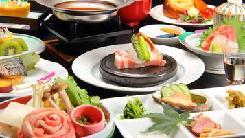 A variety of dishes including sushi, sashimi, and vegetables, suggesting a Japanese dining experience.
