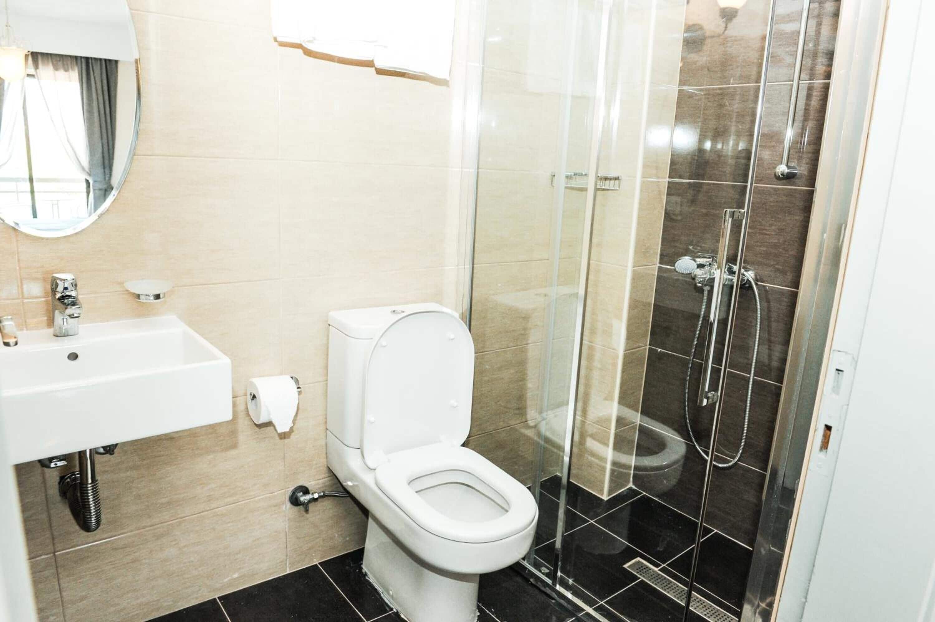 A bathroom with a toilet, sink, and shower.